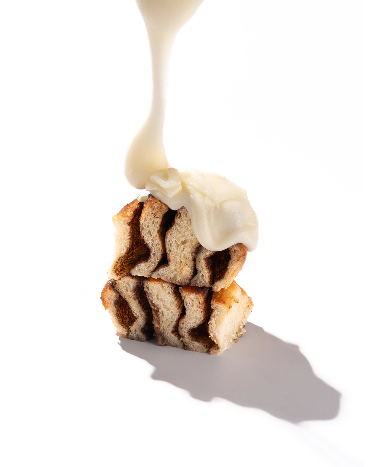 Rol de canela con glaseado de queso, fotografía de producto sobre fondo blanco