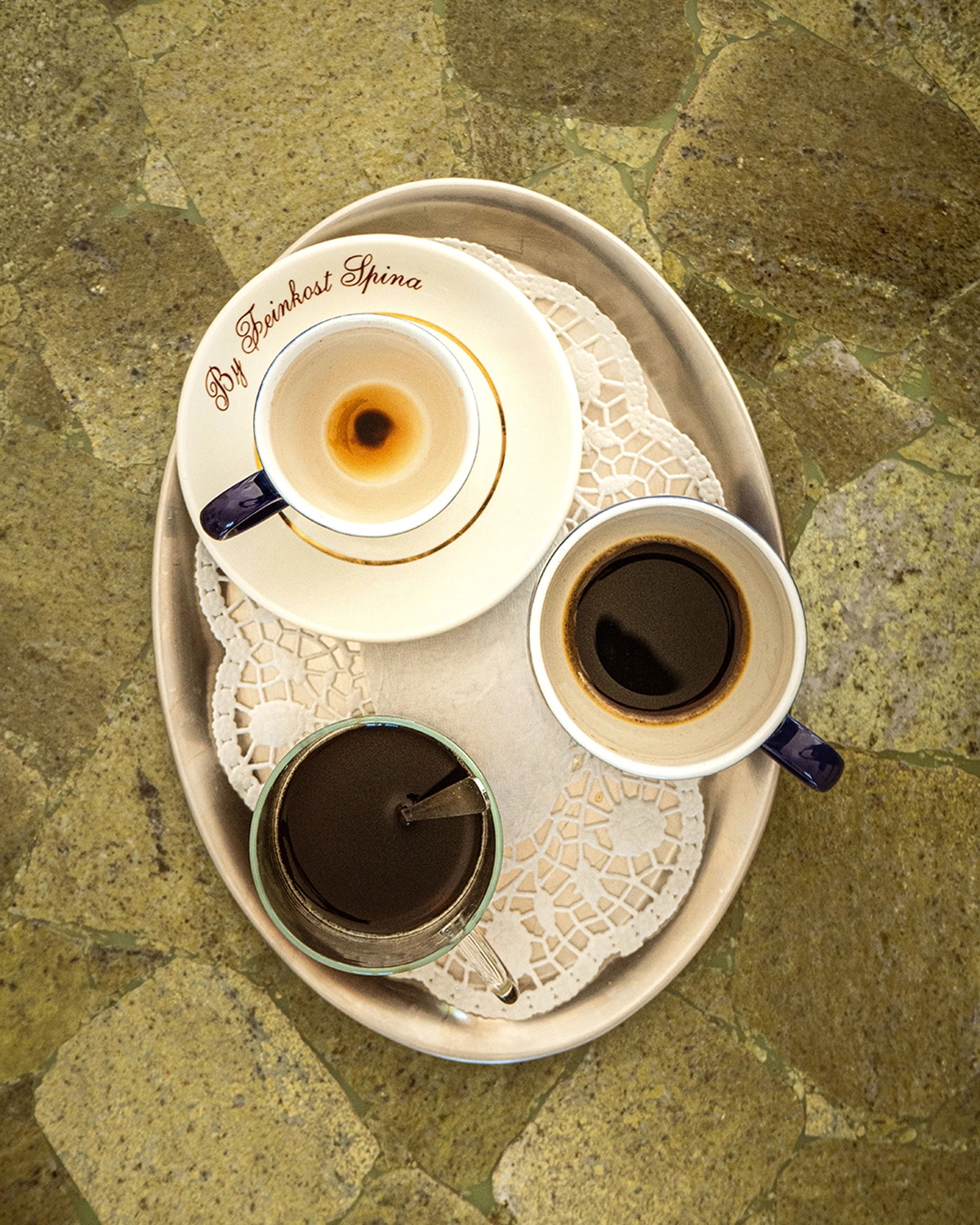 Tazas de café sobre bandeja de acero, fotografía cenital de vajilla