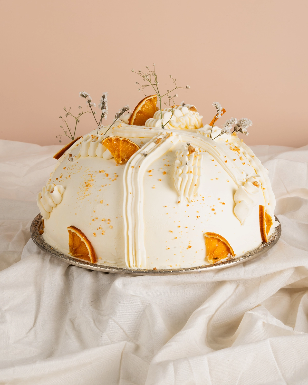 Torta con crema y naranjas deshidratadas fotografiada en estudio